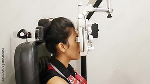 Young woman doing eye test with a phoropter instrument in an ophthalmologic clinic Stock Video