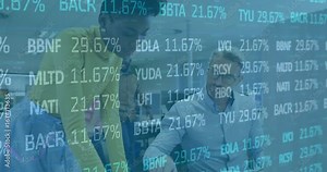 Analyst gesturing at monitor launching overlay while colleague typing tracking finance line graph