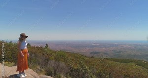 Drone Reveal Shot of Young Female Model in Summertime Standing on Rocky Outcrop of Serra de Monchique, Portugal Stock Video
