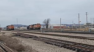 12/7/25, Sunday, BNSF Cherokee Yard (CY), Tulsa OK. As the hostlers take the Distributed Power Unit (DPU) from the Priority Manifest Galesburg, IL to Tulsa, OK (H GALTUL) to pick up another DPU to take the the diesel shop for servicing, the CY trimmer tower clears the Priority Manifest Waynoka, OK to Tulsa, OK (H WNKTUL) to come around the east leg of the wye track and prepare to back into the yard. | Ken Madison