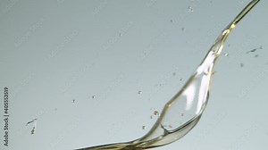Super slow motion of splashing oil on grey background. Filmed on high speed cinema camera, 1000 fps