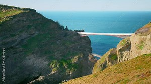 Tintagel Castle bridge, Island in Cornwall, England UK un 4K. Supposed birthplace of King Arthur with a rugged, cliff-top backdrop, on-site cafe and souvenirs, scenic rocky views with bridge steps. ▲