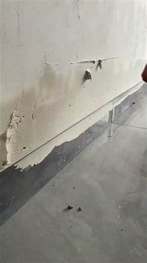 Wall plaster peeling revealing unfinished base layer