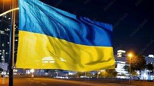 Ukrainian flag waving at night with modern city lights illuminating the background. Stock Video