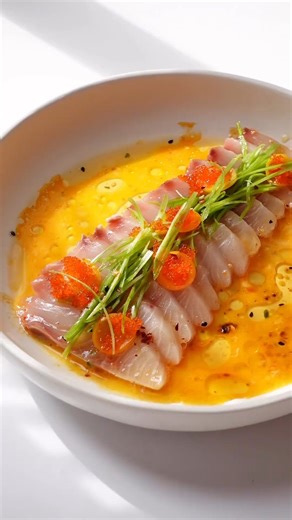 Charles Calvino shared his reel for hamachi crudo, a delicious and popular Japanese appetizer consisting of yellowtail sashimi and a light, but flavorful dressing.🐟 With notes of spice and citrus, this recipe is sure to impress!😋 🎥: @charlescalvino on Instagram | Mitsuwa Marketplace