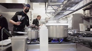 Diverse group of chefs preparing food in restaurant kitchen. Working in a busy restaurant kitchen. High quality FullHD footage