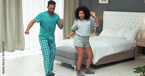 Dance, love and fun with a couple dancing together in the bedroom of their home. Carefree, choreography and happy with a young man and woman dancer feeling cheerful and positive in their house