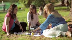 awesome girls eating fruits outdoor in the park: having fun, smiling, talking