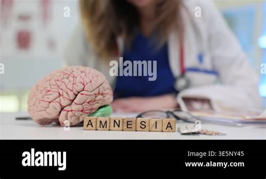 Word Amnesia created from wooden cubes by anatomical model of brain. Woman doctor calmly writes detailed stages of recovery for patient at appointment Stock Video Footage - Alamy