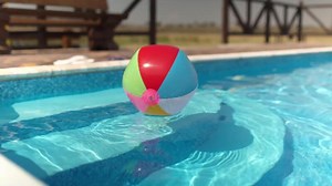 Turquoise pool water with floating inflatable ball