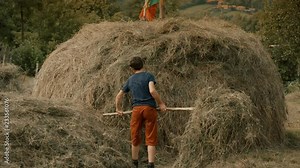 Two boys are building a haystack