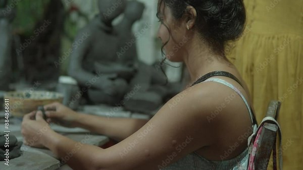 Woman sculpting clay figure at a pottery workshop, focused and engaged in her craft Stock Video