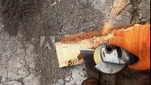 Man sharpen ax with electric device down