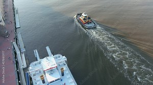 tilt aerial footage of the rippling blue waters of the Savannah River and the Talmadge Memorial Bridge with boats, ships, blue sky and clouds at sunset in Savannah Georgia USA