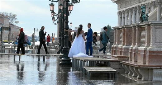 Nelle calli e in piazza San Marco torna l'acqua alta: cittadini e turisti camminano sulle passerelle