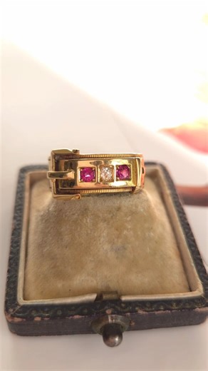 A Christmas gift with history woven into every detail. This Victorian 18ct gold buckle ring, set with natural rubies (~0.18ct) and an old mine cut diamond (~0.08ct), carries the timeless symbolism of love, loyalty, and an unbreakable bond. Hand-crafted in 1892 and fully hallmarked, its classic buckle design—once worn by the Order of the Garter—became a cherished token of devotion throughout the Georgian and Victorian eras. A warm, buttery gold glow, a textured rim, and its trio of gemstones make