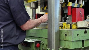 Steel Manufacturing Plant. A Worker is Placing a Piece of Metal Inside the Press. The Press is pushed Down. Metallurgy. Production Process. Close up. High quality 4k footage