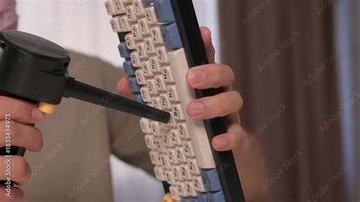 Closeup showing detailed cleaning of keyboard keys, Demonstration of meticulous keyboard cleaning involving dust removal and careful inspection in home environment
