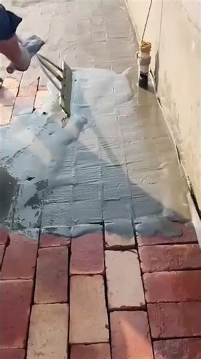 Worker spreading cement slurry over red brick pavement #shorts