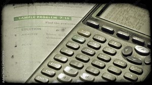Close-up pan of math textbook and graphing calculator. Vintage stylized video clip.