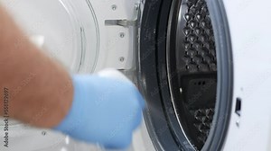 Man Doing Periodic Maintenance, Cleaning the Washing Machine. A Housekeeper Washing and Cleaning a Laundry Machine.