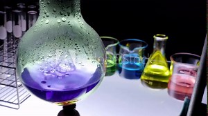 close up alcohol lamp is boiling chemical liquid color in flask with lab glassware on black background. laboratory research and development