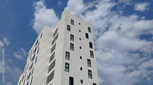 White Color Commercial Residential Building Complex with Black Color Windows And Blue Sky Background. Highrise Skyscraper Building Exterior Outdoor Full View. G+10 floor Tallest Skyline With PentHouse