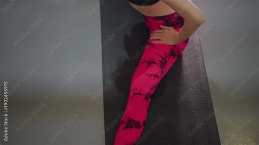 asian woman seated stretch on mat, close top view showing pink leggings, focused breath and slow mobility for hamstring recovery yoga student and rehab client vibe, gentle guidance from trainer, calm