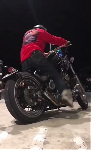 Biker girl kickstarting Harley-Davidson shovelhead motorcycle