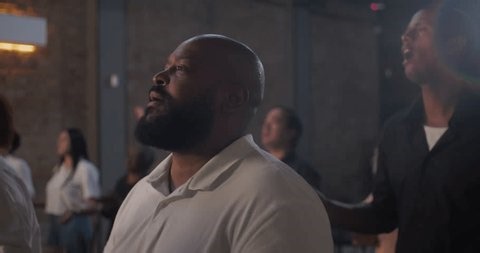 Man passionately clapping hands during worship service, showing spiritual connection, faith, and devotion in a diverse church community setting