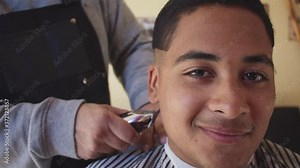 hairdresser shaving the neck of his client, with machine, client happy for his cut and style