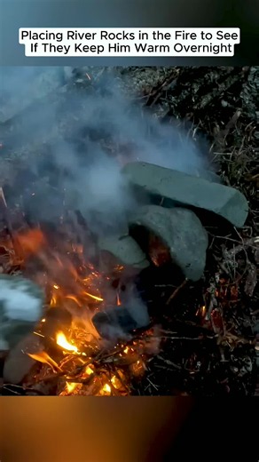 Placing river rocks in the fire to stay warm overnight