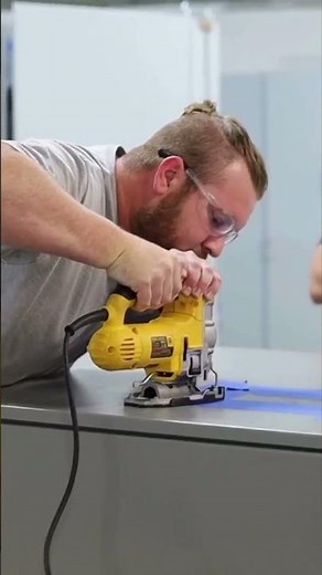 Installing an HMI screen on a control panel cabinet.