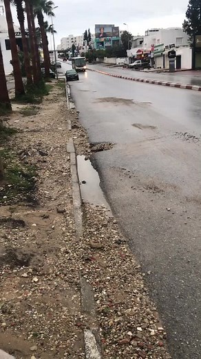 Urban Street Scene with Moving Bus and Wet Pavement