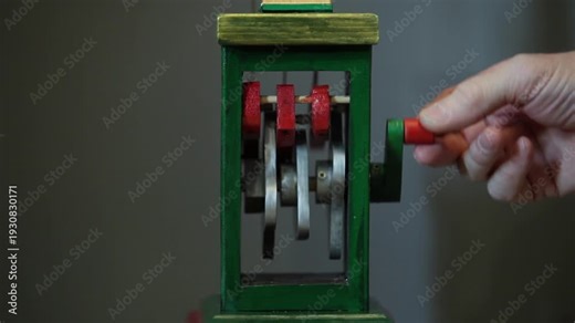 man turns the handle of an antique wooden mechanism, close-up, loop, with sound