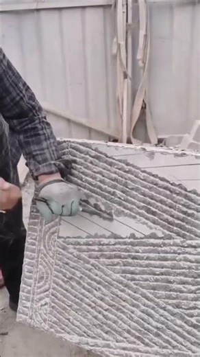 Someone manually carves geometric line patterns on a cement wall panel #construction #popular