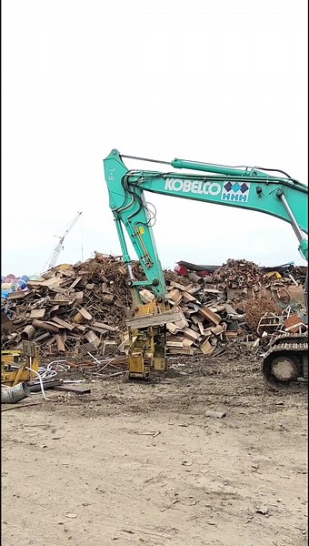 Powerful Excavator Lifts Scrap Metal Effortlessly