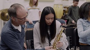 clip-3513997267-junior-high-music-teacher-helping-student-playing