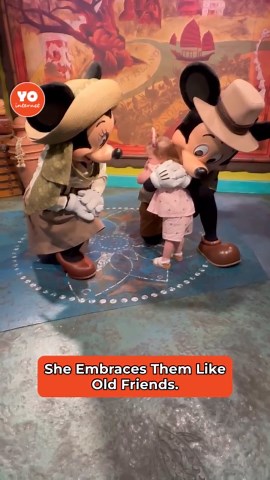 Adorable girl encounters Mickey and Minnie Mouse for the first time