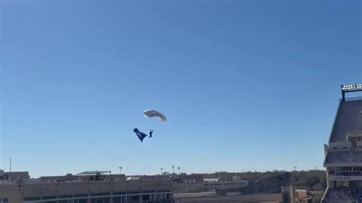 Skydiver gets caught in net while parachuting into football game