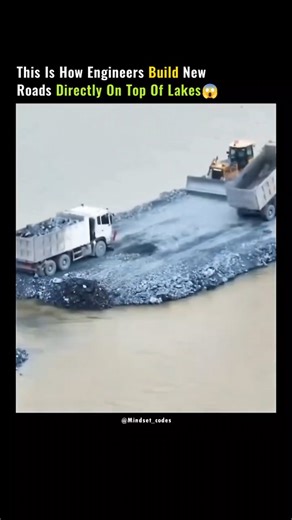 MOTIVATION | INSPIRATION | QUOTES on Instagram: "This is how engineers create real, driveable roads in places where there was never land at all. The process starts by dumping massive volumes of rock and aggregate directly into the water, forming a stable base that displaces soft sediment and spreads weight evenly across the lakebed. Heavy machinery then compacts each layer, forcing water out and locking the stones together through friction and pressure. Once the base reaches the surface, enginee