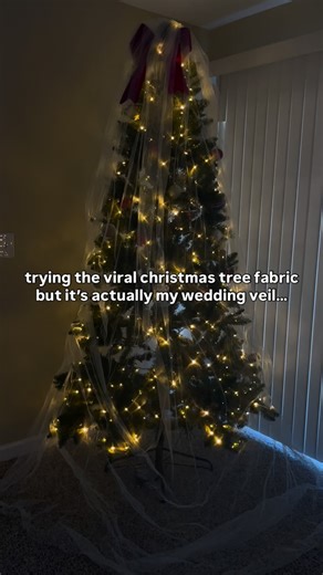 first christmas as a “mrs.” vibes? 🎄🤍 when I first saw this idea on facebook, I just knew that I had to try it! it’s definitely a more modern approach to christmas for sure!! but what do you guys think? should we see more fabric on trees this holiday season? and could this be a new tradition for future brides? ✨ • • • #christmas #bride #weddingveil #christmastree #christmasdecor #weddingtrends #weddingtraditions #bride2025 #christmasdecorideas #veil #weddingveilideas | Hannah Adrianna Photogra