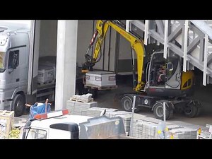 Wacker Neuson 6503 unloading Truck with Engcon tiltrotator and pallet forks