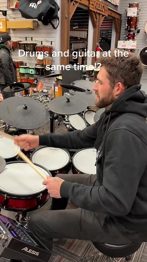 Musician Playing Drums and Guitar Simultaneously