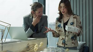 Young Asian Interior and caucasian Architect working with architectural model model house design ideas concept.Designer group brain storming in a meeting at modern office in urban city.