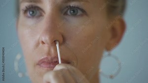 Close up of woman performing at home nasal PCR self test for covid-19