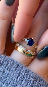 BLUE SAPPHIRE ENGAGEMENT RING A crescendo in diamond, the Coda Ring features a round cut blue sapphire at the center of four round cut accent diamonds. But that’s not all, four hidden diamonds are tucked beneath the setting, carrying this diamond echo to every element of this unique engagement ring. We love the blue sapphire Coda Ring paired with a winter-inspired band, like the Wide First Frost Band seen here. This composition uses icicle-like marquise diamond accents to complement the deep, wi