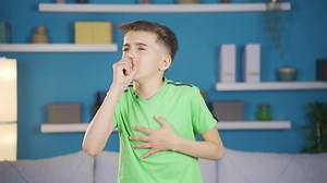 The sick boy is coughing and having shortness of breath.