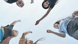 Cheerful female friends join hands against a blue sky as a sign of strong friendship.