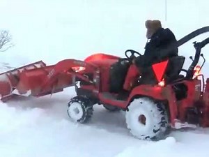 Kubota BX clearing snow with BXpanded plow and the tractor bucket